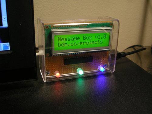 Clear plastic box with a circuit board with an LCD module and a couple of LEDs in it