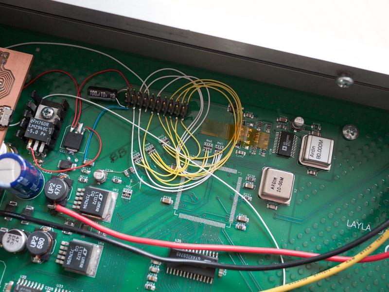 close-up of the header for the microcontroller board with wires going
        to the lines for controlling the input gains
