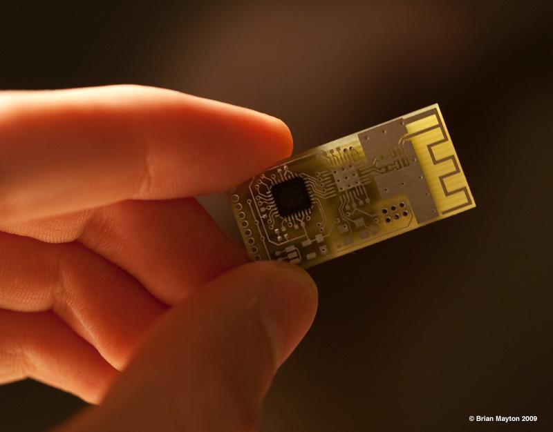 hand holding a small backlit circuit board with a microcontroller and
    trace antenna